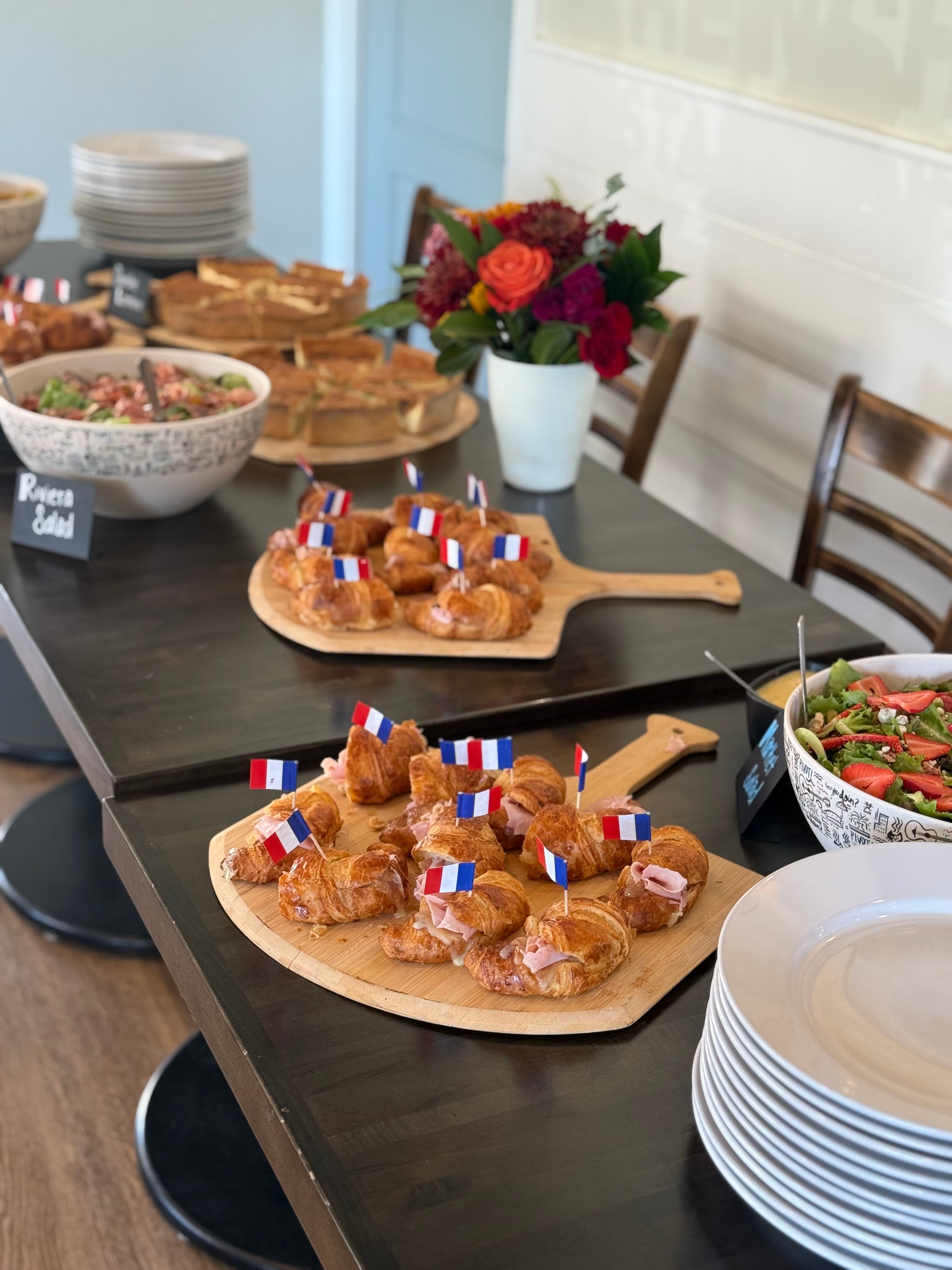 Paulette Cafe pastry table with croissants and French flags